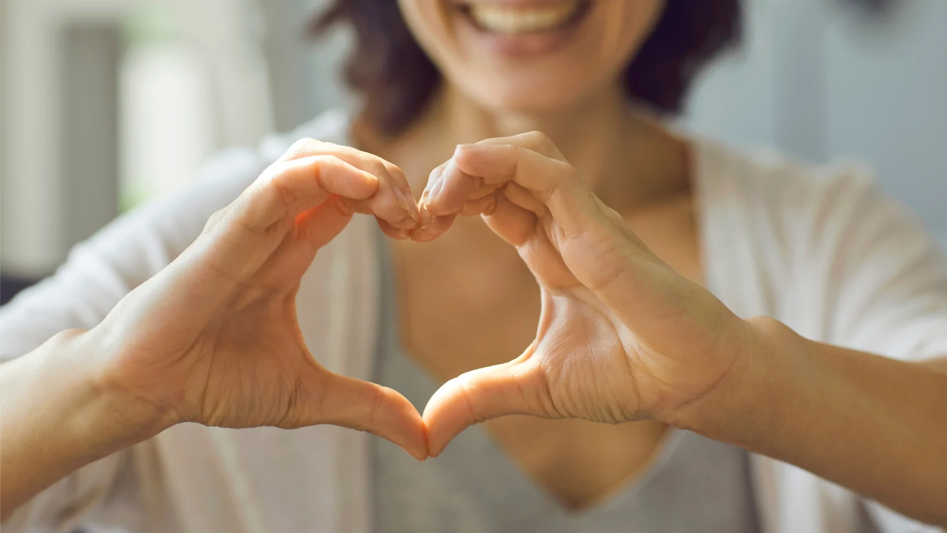 woman making heart for a healthy volunteer research study